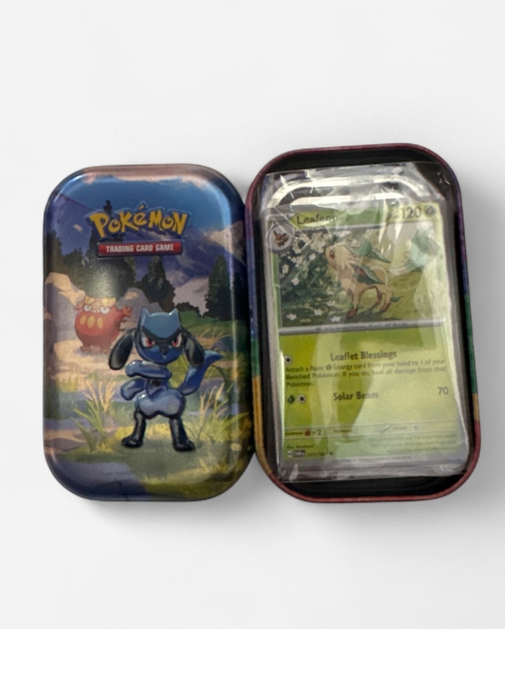 About 100 Pokemon cards in riolu Tin